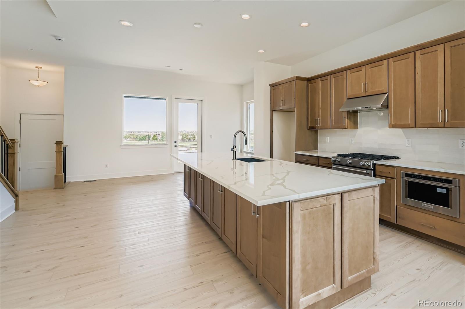622 Saddle Drive Erie, CO 80516 - Photo 5 of 25 a kitchen with kitchen island a sink stove and refrigerator