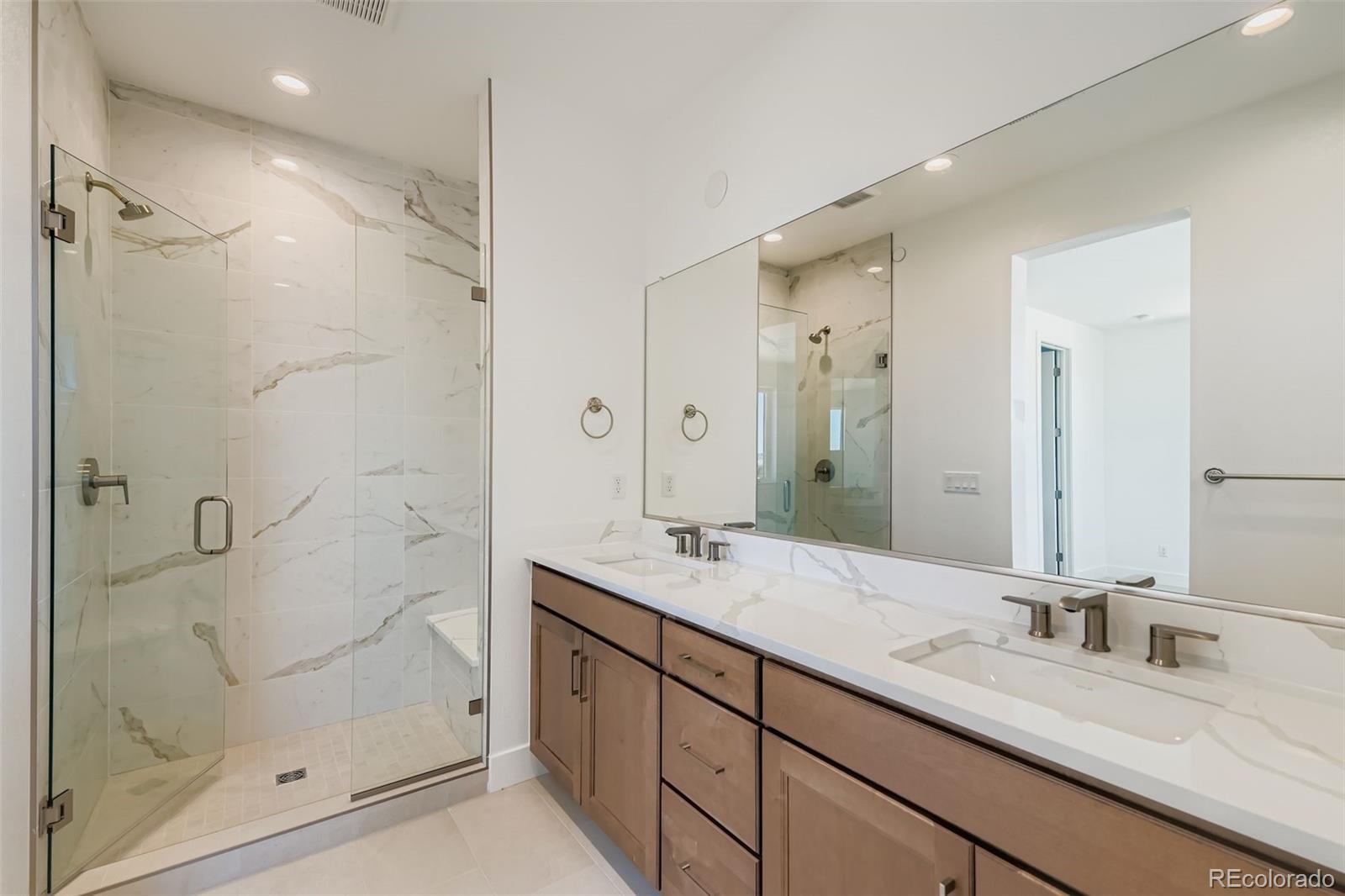 622 Saddle Drive Erie, CO 80516 - Photo 8 of 25 a bathroom with a granite countertop sink mirror and shower