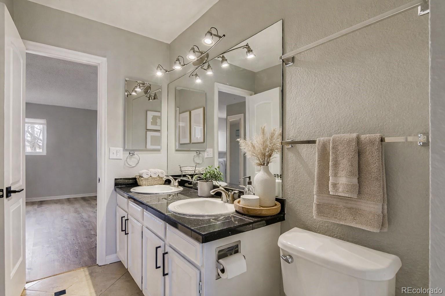 1060 South Parker Road, Unit 25 Denver, CO 80231 - Photo 11 of 26 a bathroom with a sink a toilet and a mirror