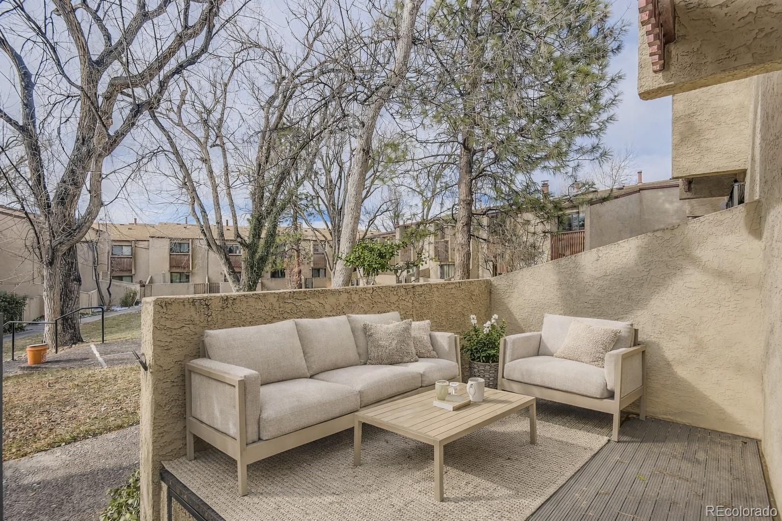 1060 South Parker Road, Unit 25 Denver, CO 80231 - Photo 12 of 26 a view of a patio with couches and a large tree