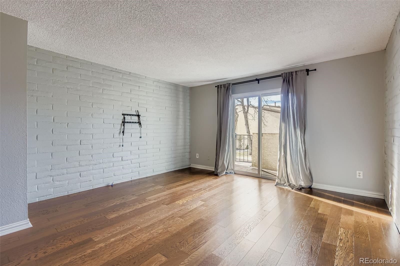 1060 South Parker Road, Unit 25 Denver, CO 80231 - Photo 13 of 26 an empty room with wooden floor and windows