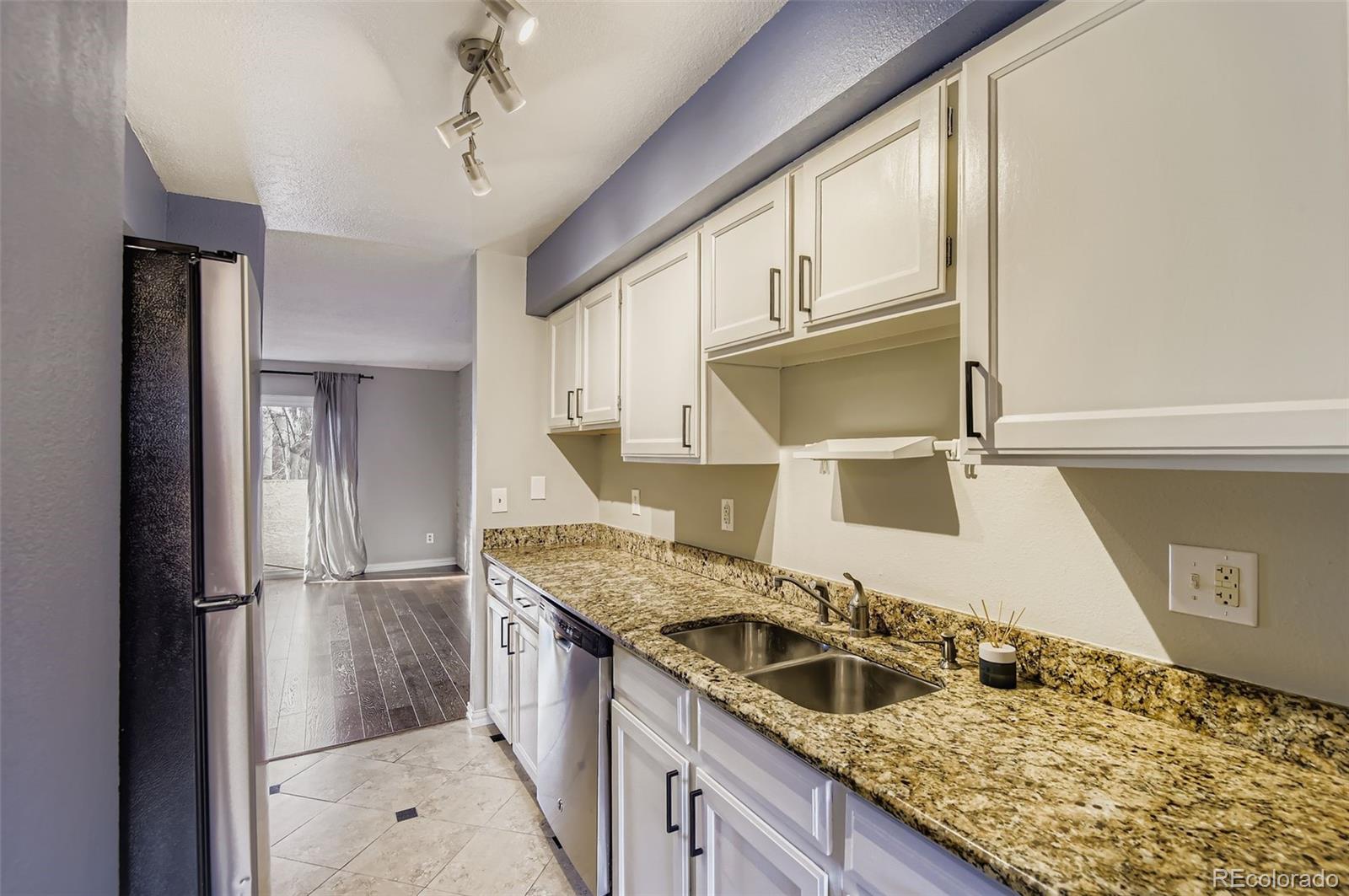 1060 South Parker Road, Unit 25 Denver, CO 80231 - Photo 16 of 26 a kitchen with a sink a refrigerator and cabinets