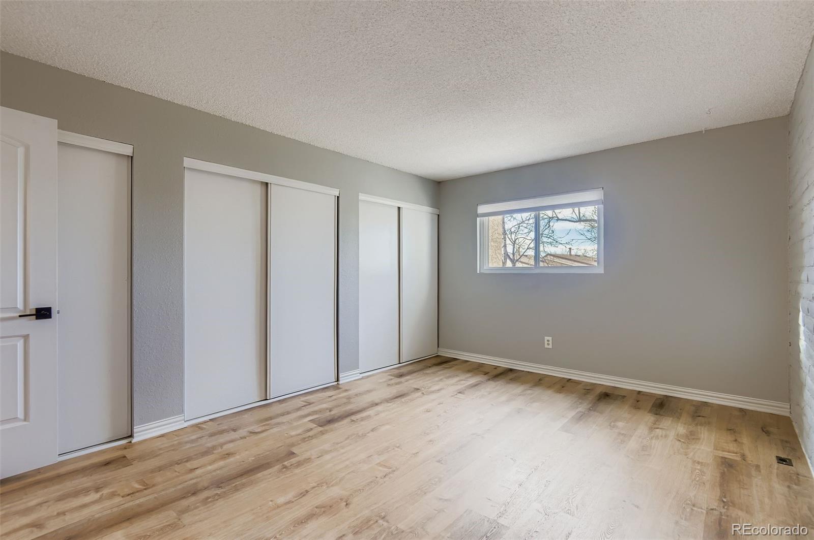 1060 South Parker Road, Unit 25 Denver, CO 80231 - Photo 18 of 26 a view of an empty room with wooden floor and a window