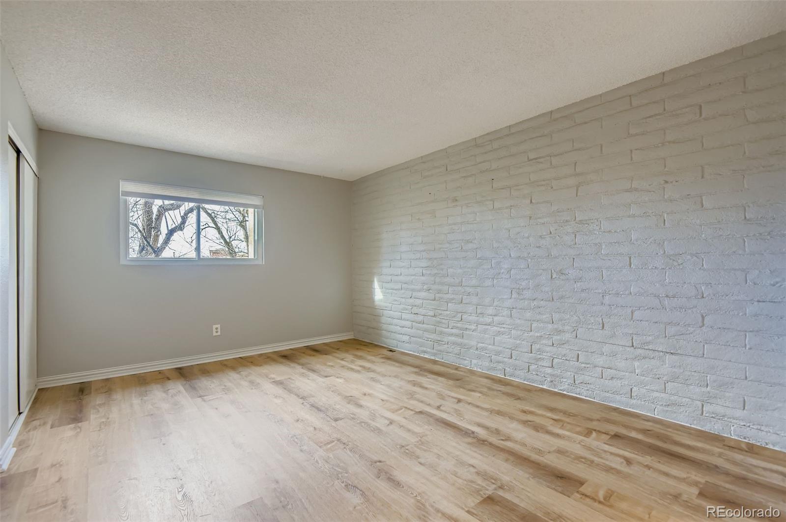 1060 South Parker Road, Unit 25 Denver, CO 80231 - Photo 19 of 26 a view of an empty room with wooden floor and a window