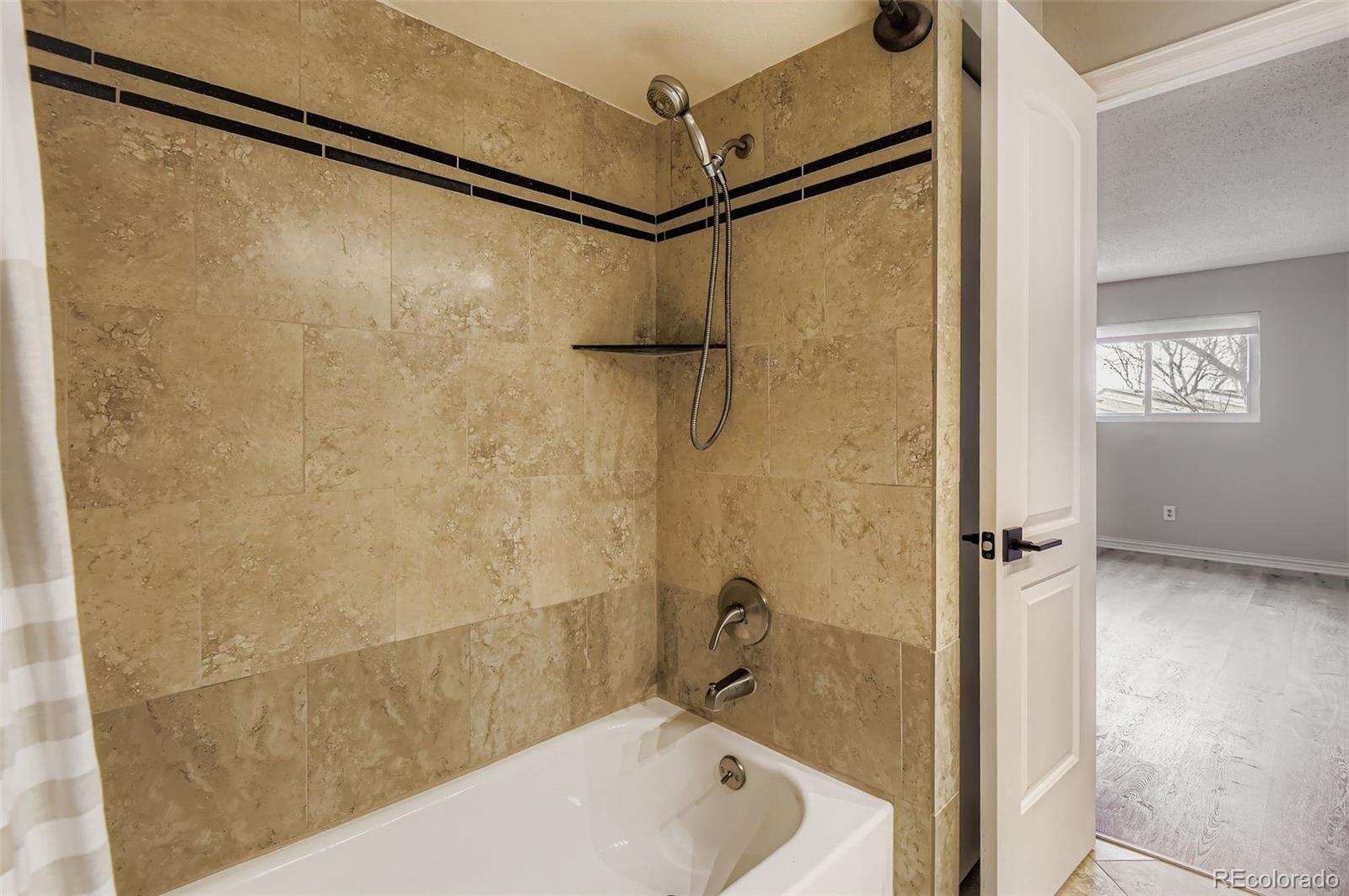 1060 South Parker Road, Unit 25 Denver, CO 80231 - Photo 21 of 26 a bathroom with a shower and a bathtub