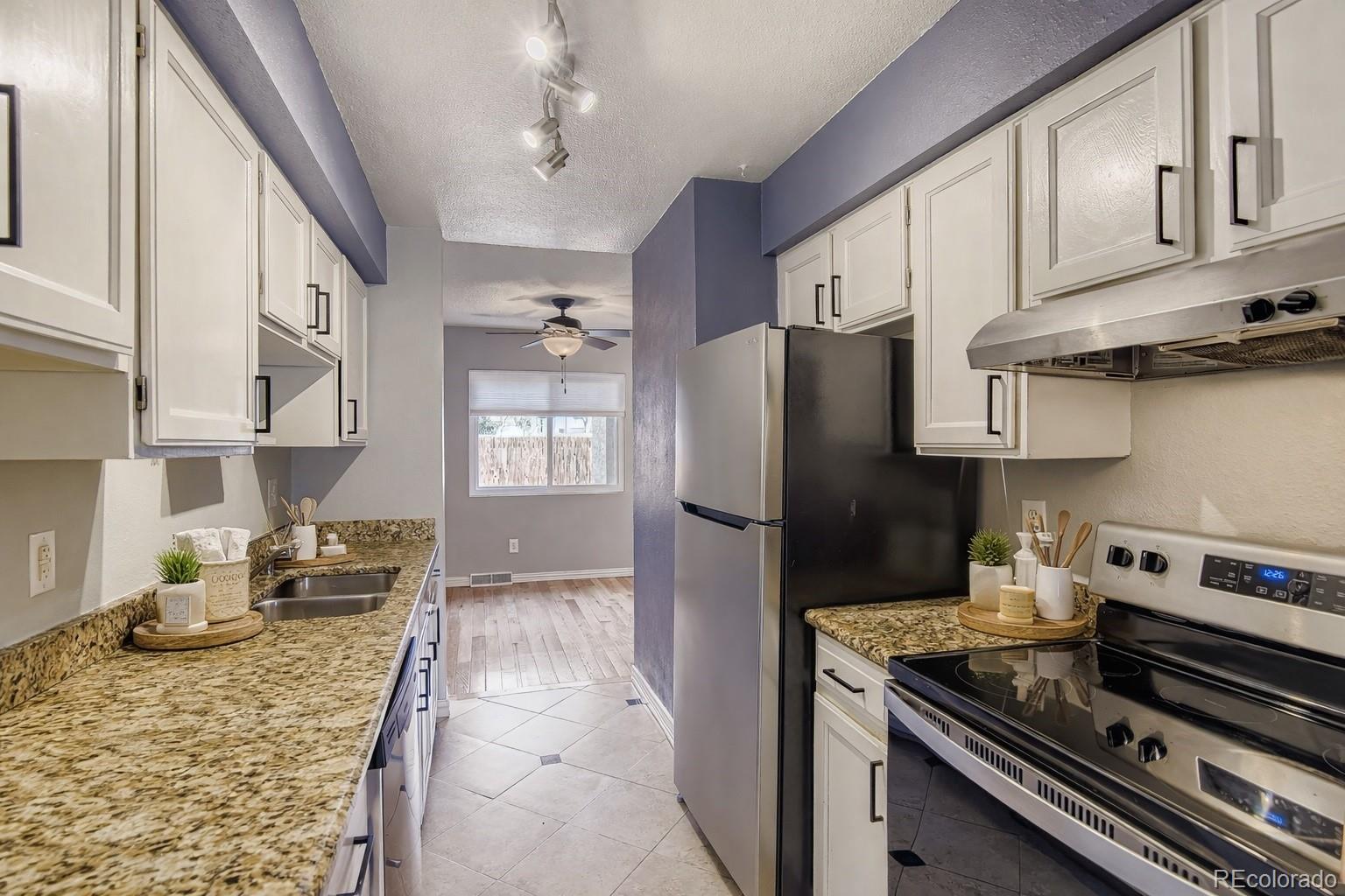 1060 South Parker Road, Unit 25 Denver, CO 80231 - Photo 7 of 26 a kitchen with stainless steel appliances granite countertop a stove refrigerator and cabinets