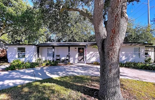 a view of a house with a tree in a yard