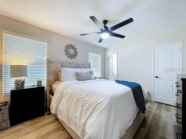 a bedroom with a bed and wooden floor