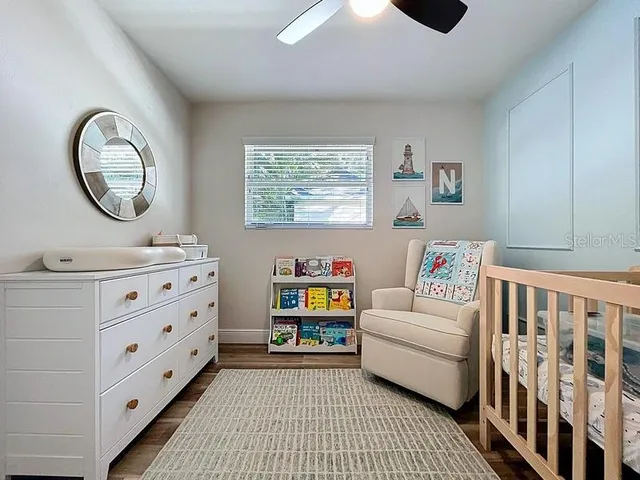 a living room with furniture and a baby crib