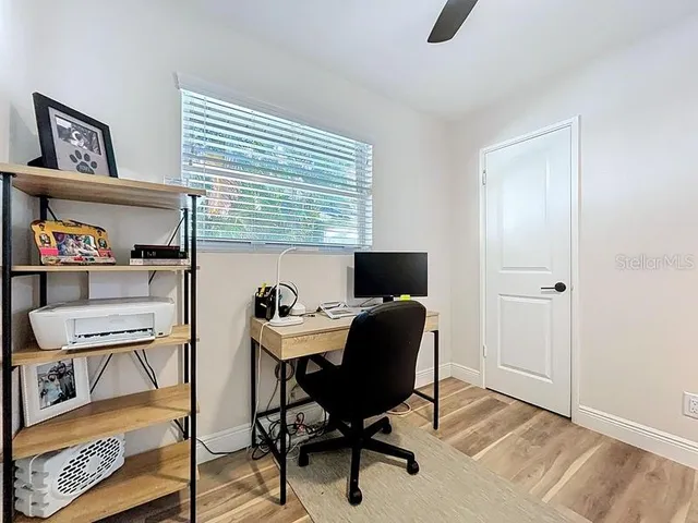 a view of a workspace with furniture and a window