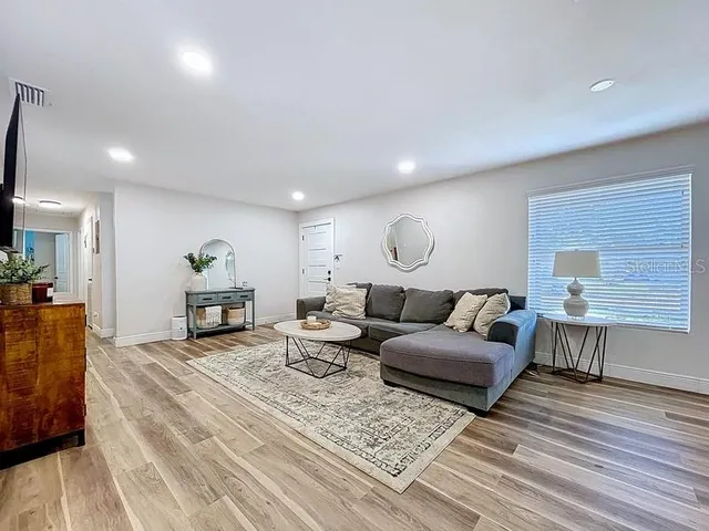 a living room with furniture and a wooden floor