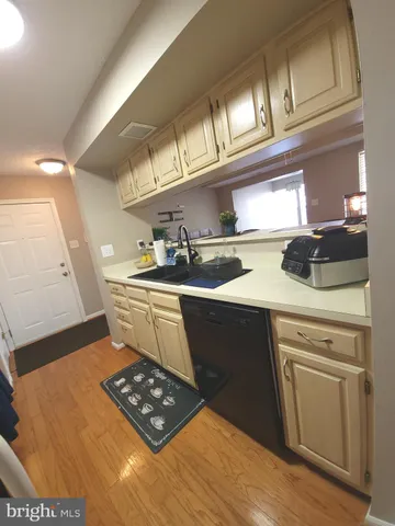 a kitchen with a sink a stove cabinets and wooden floor