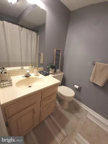 a bathroom with a toilet a sink and mirror