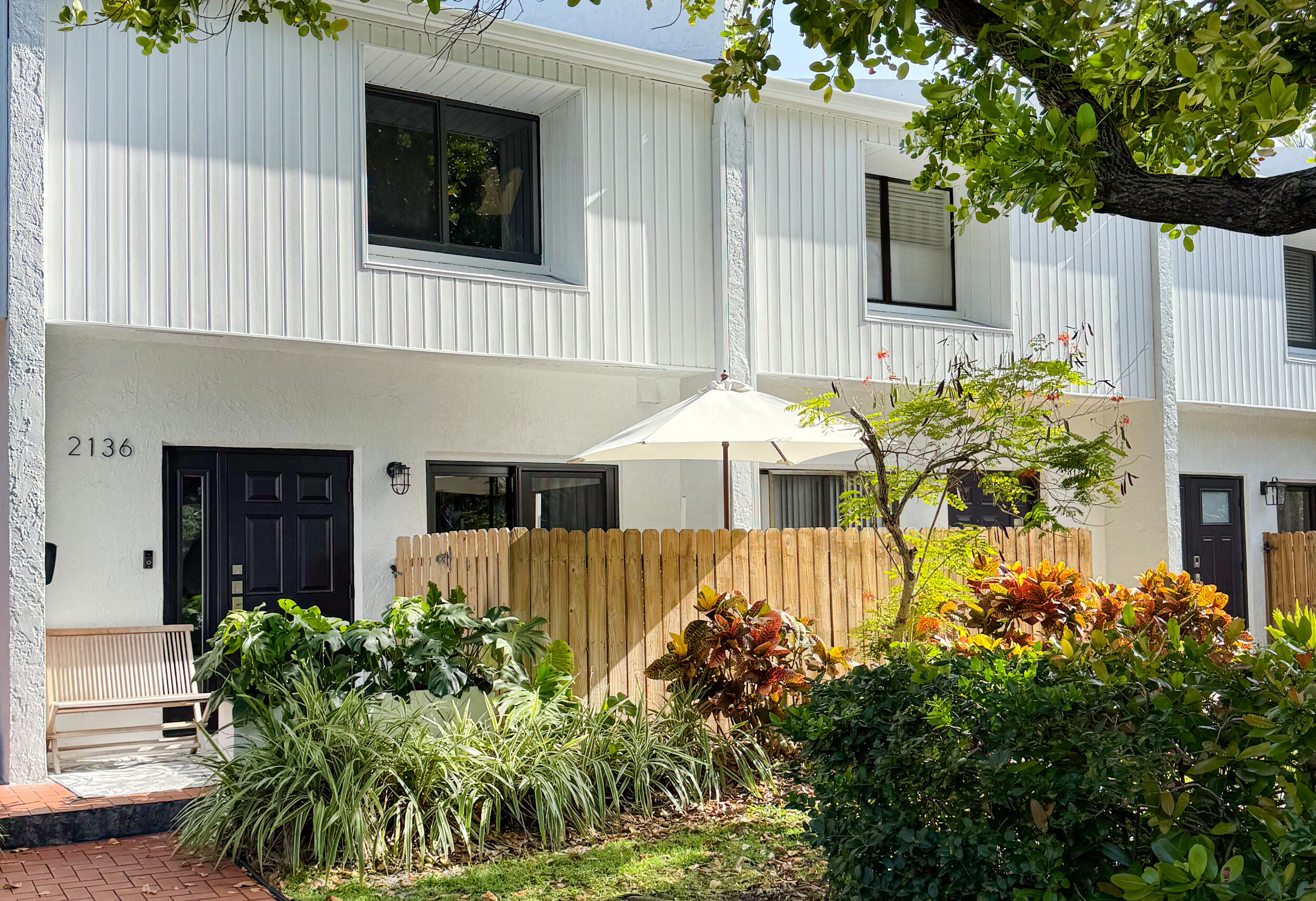 a front view of a house with plants