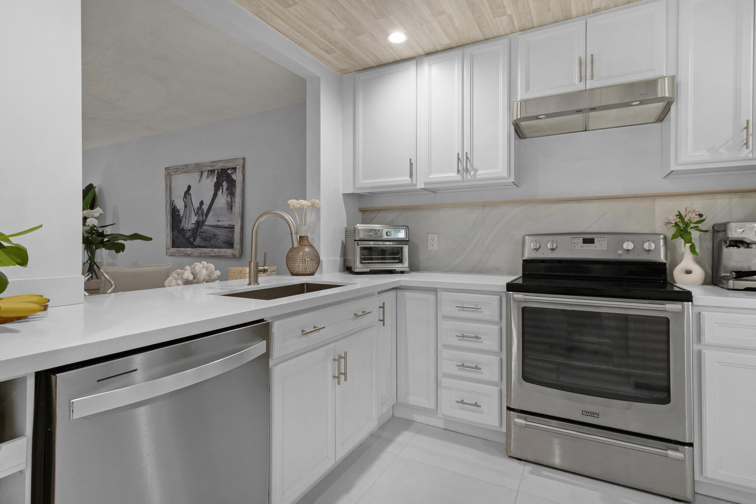 2136 Northeast 44th Street, Unit 4 Lighthouse Point, FL 33064 - Photo 6 of 51 a kitchen with white cabinets stainless steel appliances and sink