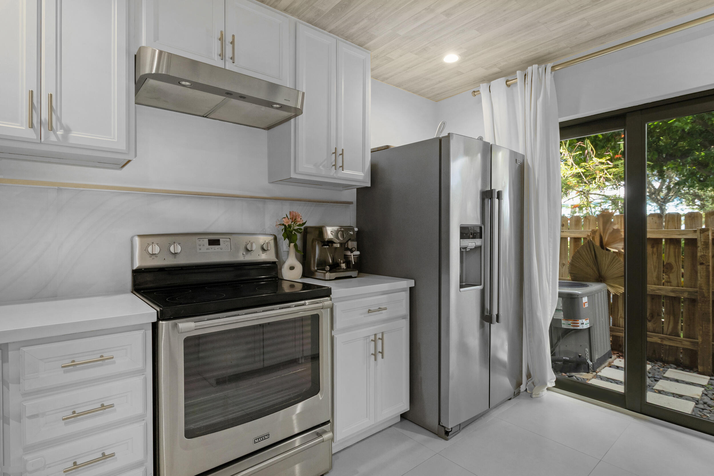 2136 Northeast 44th Street, Unit 4 Lighthouse Point, FL 33064 - Photo 7 of 51 a kitchen with stainless steel appliances white cabinets and a stove top oven