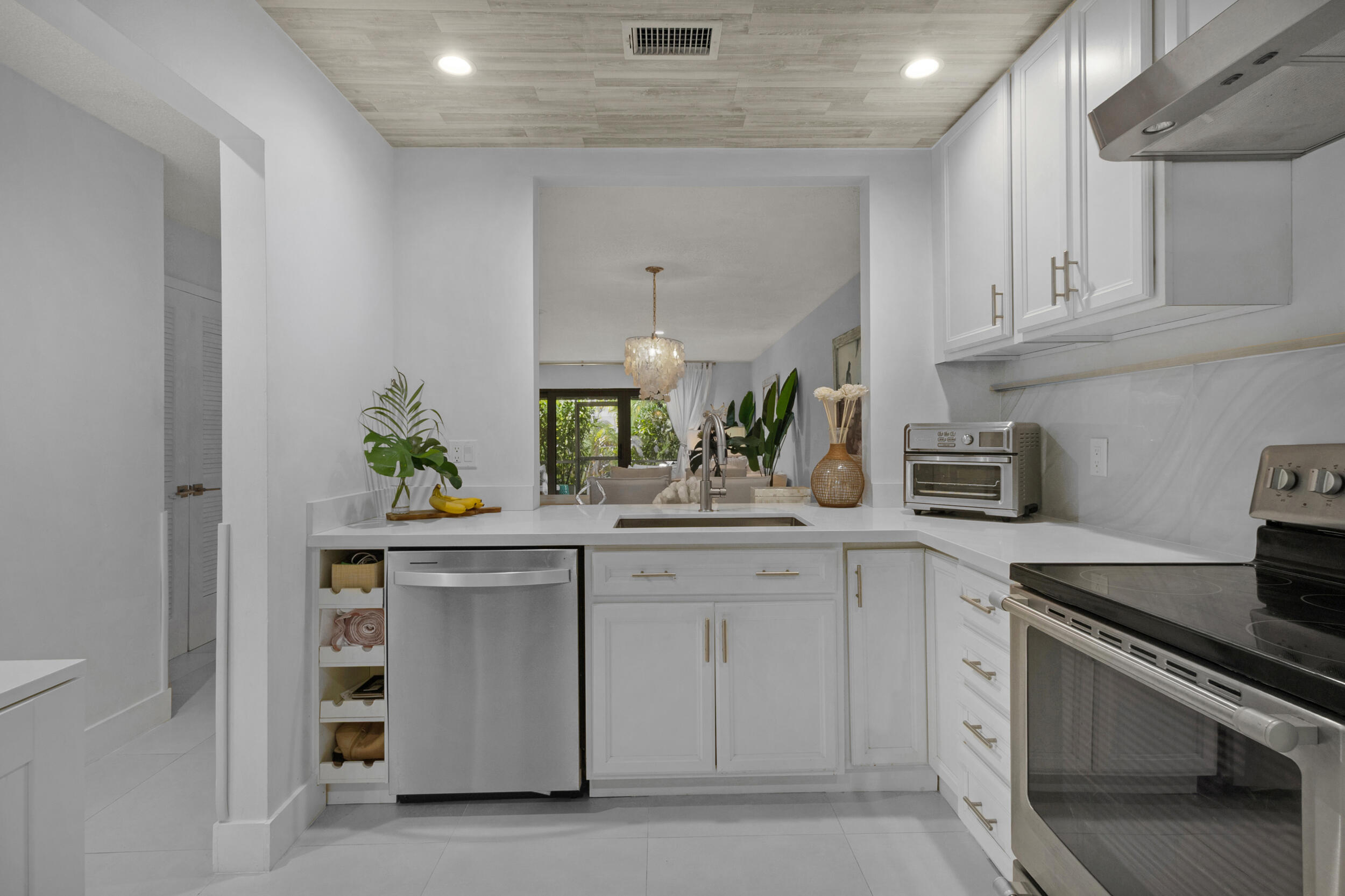 2136 Northeast 44th Street, Unit 4 Lighthouse Point, FL 33064 - Photo 10 of 51 a kitchen with white cabinets and appliances
