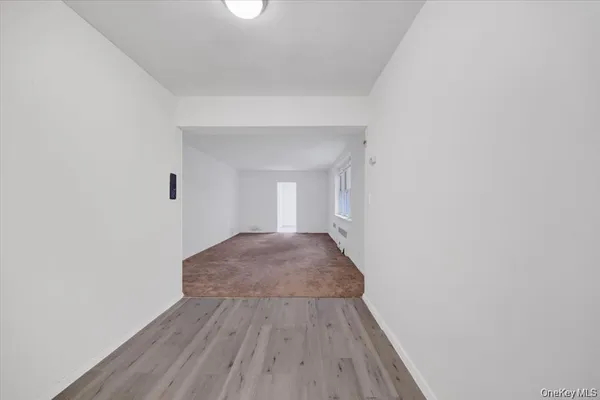 a view of a room with wooden floor and white walls