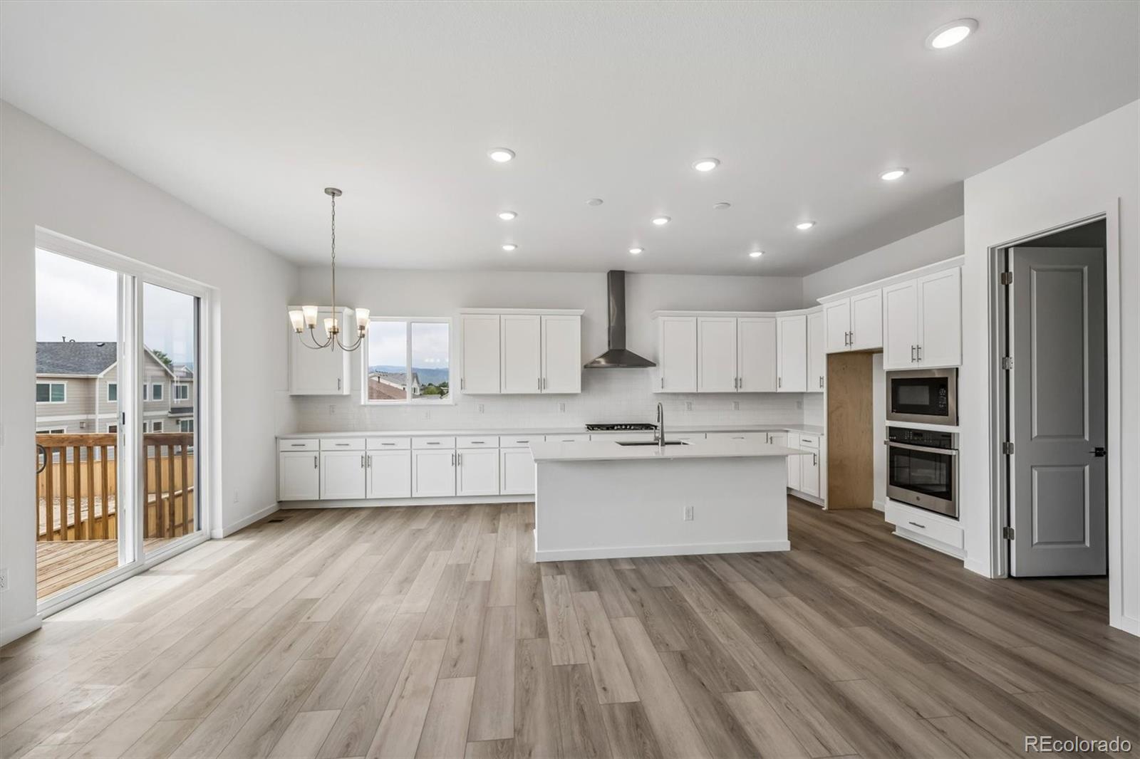 2516 West Bitterroot Place Highlands Ranch, CO 80129 - Photo 11 of 24 a large kitchen with cabinets wooden floor and stainless steel appliances