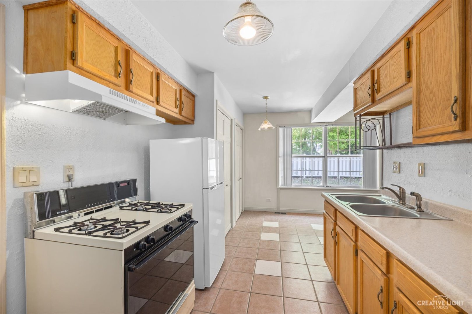 1520 Timber Trail, Unit 17B Wheaton, IL 60189 - Photo 11 of 17 a kitchen with a stove a sink and a refrigerator