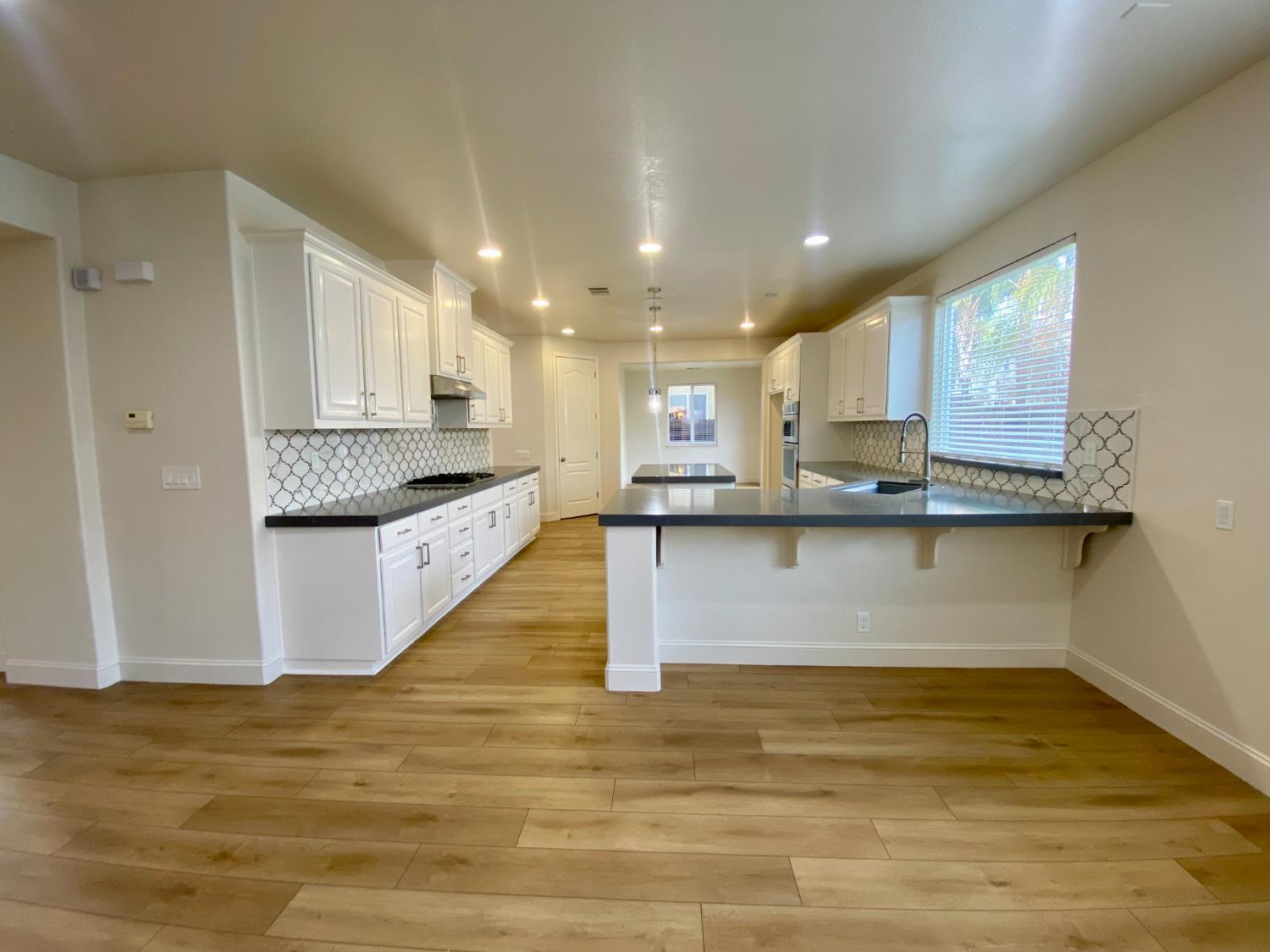 1227 CAVALAIRE Court Merced, CA 95348 - Photo 11 of 34 a large kitchen with kitchen island granite countertop a large counter top and stainless steel appliances