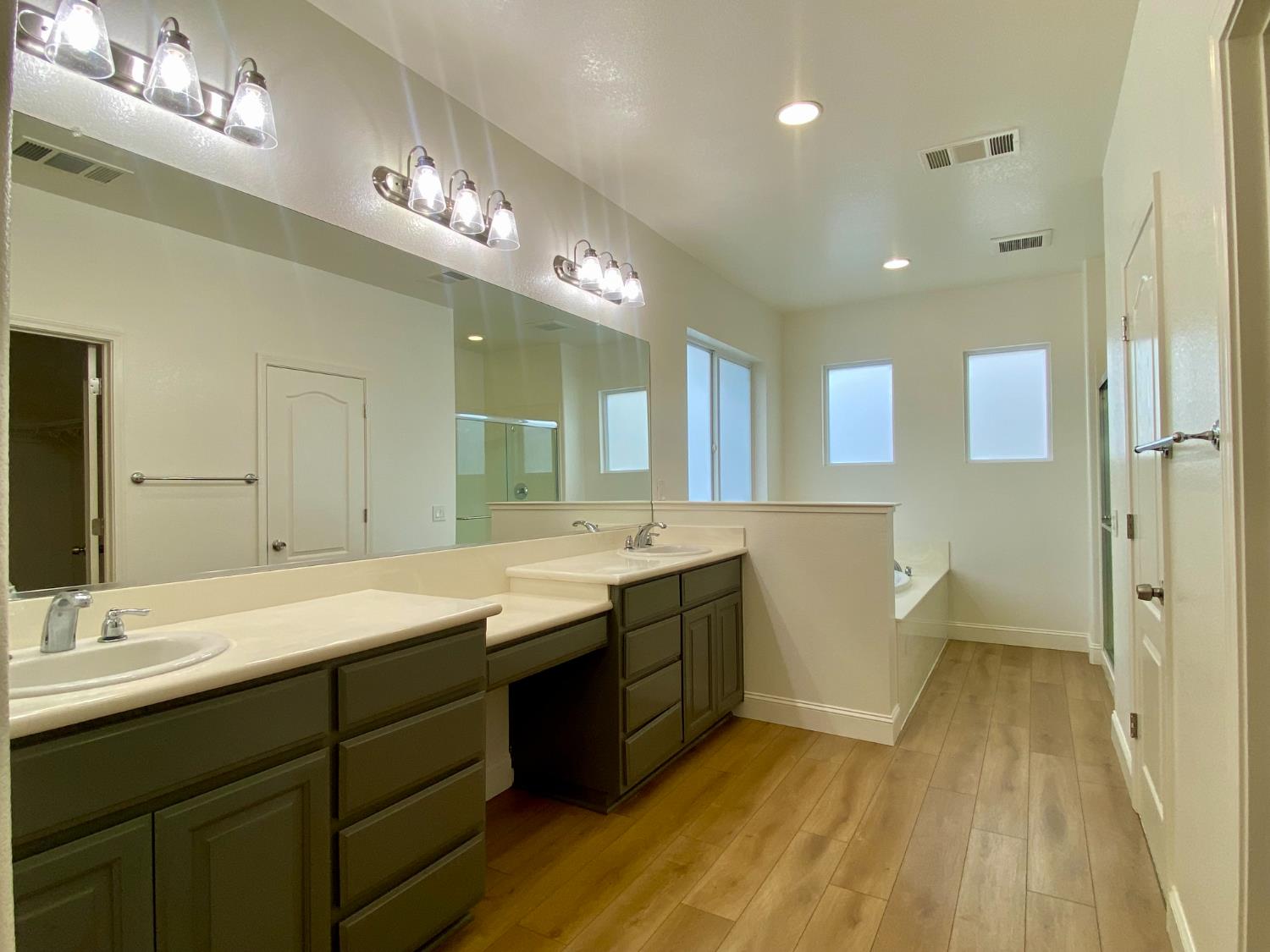 1227 CAVALAIRE Court Merced, CA 95348 - Photo 28 of 34 a spacious bathroom with a double vanity sink a large mirror and a shower