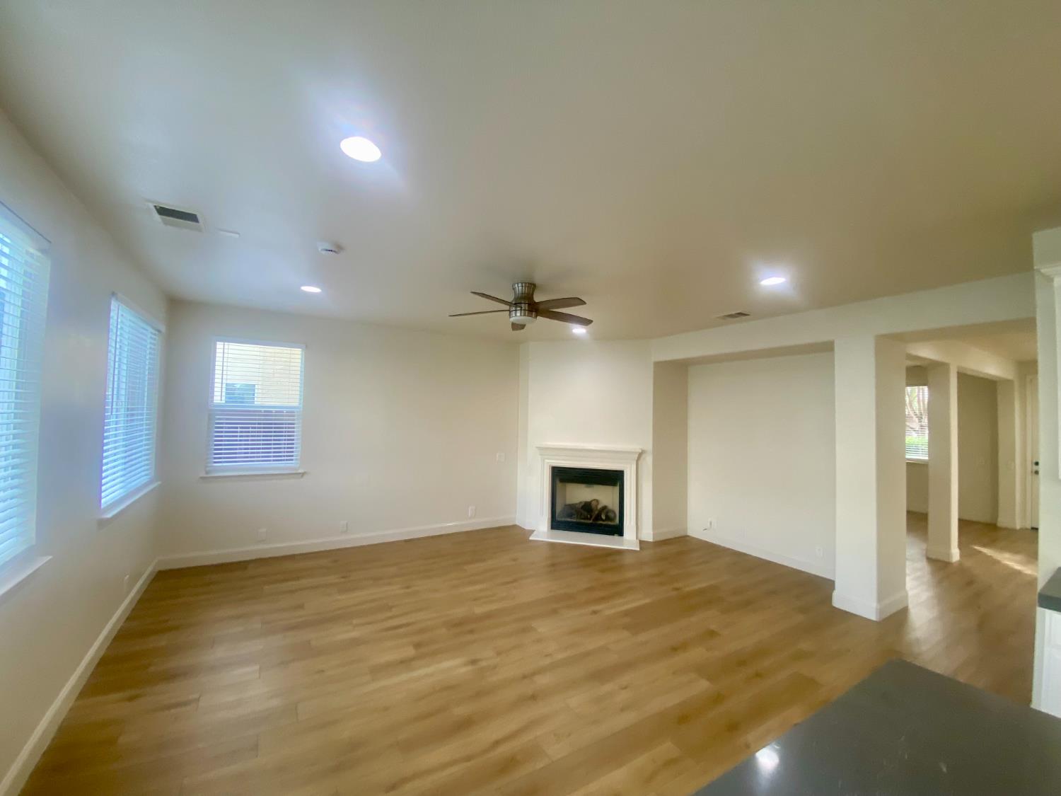 1227 CAVALAIRE Court Merced, CA 95348 - Photo 8 of 34 an empty room with a fireplace and windows