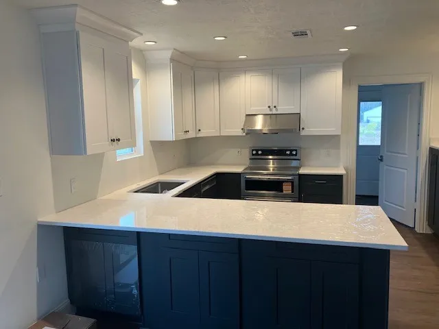 a kitchen with a wooden floor and black appliances