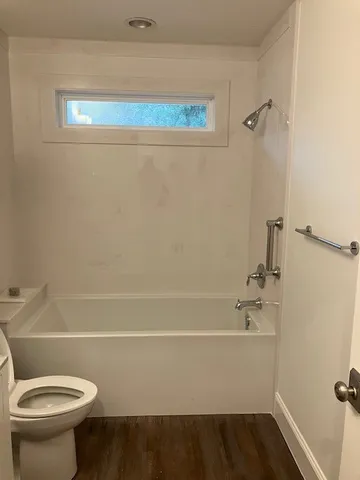 a utility room with wooden floor washer and dryer