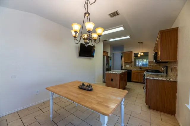 a kitchen with stainless steel appliances granite countertop a sink a stove top oven a counter space and cabinets