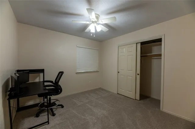 a view of a workspace with furniture and a window