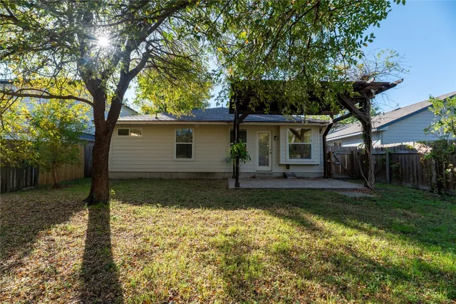 a view of a house with backyard and a tree