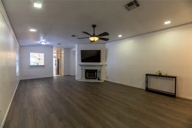 a view of an empty room with a fireplace and a window