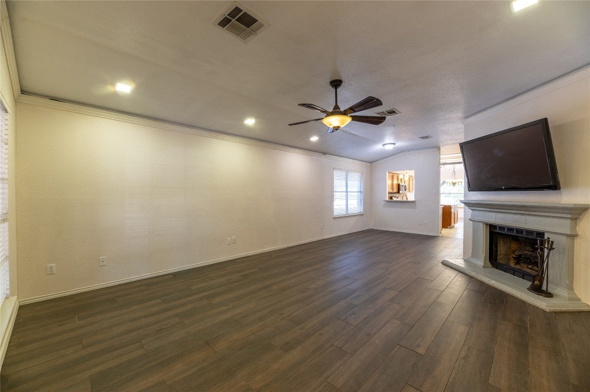 2604 Hutton Lane Leander, TX 78641 - Photo 5 of 27 an empty room with wooden floor fireplace and windows