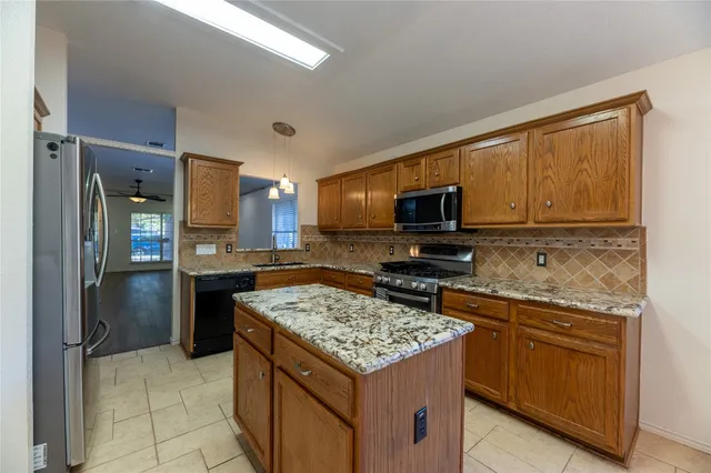 a kitchen with a stove a refrigerator and a microwave