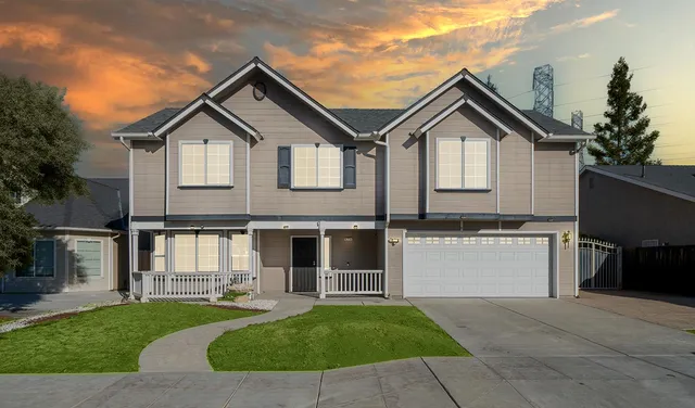 a front view of a house with a yard and a garden