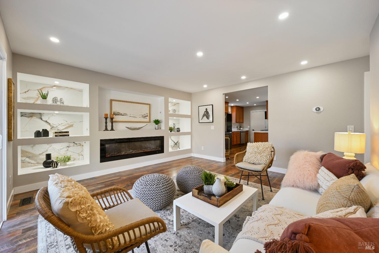 a living room with furniture and a view of kitchen