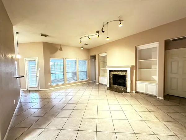 a view of an empty room with a fireplace and a window