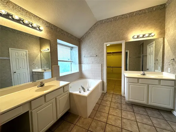 a bathroom with a tub sink and mirror