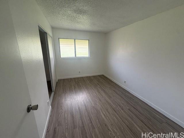 98-1370 Koaheahe Place, Unit 164 Pearl City, HI 96782 - Photo 4 of 12 an empty room with wooden floor and windows