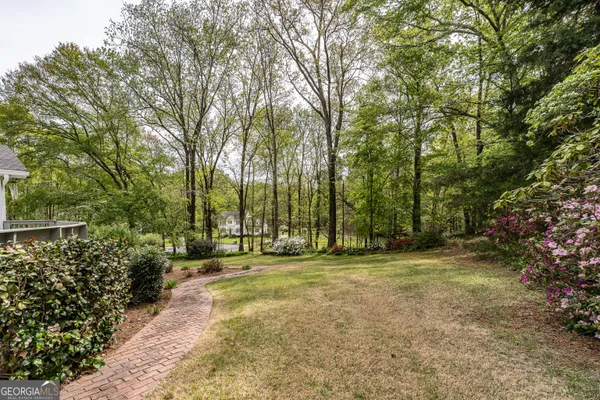 a view of a house with pool and trees in the background