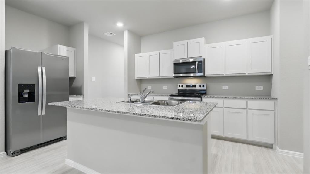 3152 Maple Orch Lane Fort Worth, TX 76140 - Photo 35 of 37 a kitchen with stainless steel appliances granite countertop a refrigerator a stove a sink and white cabinets