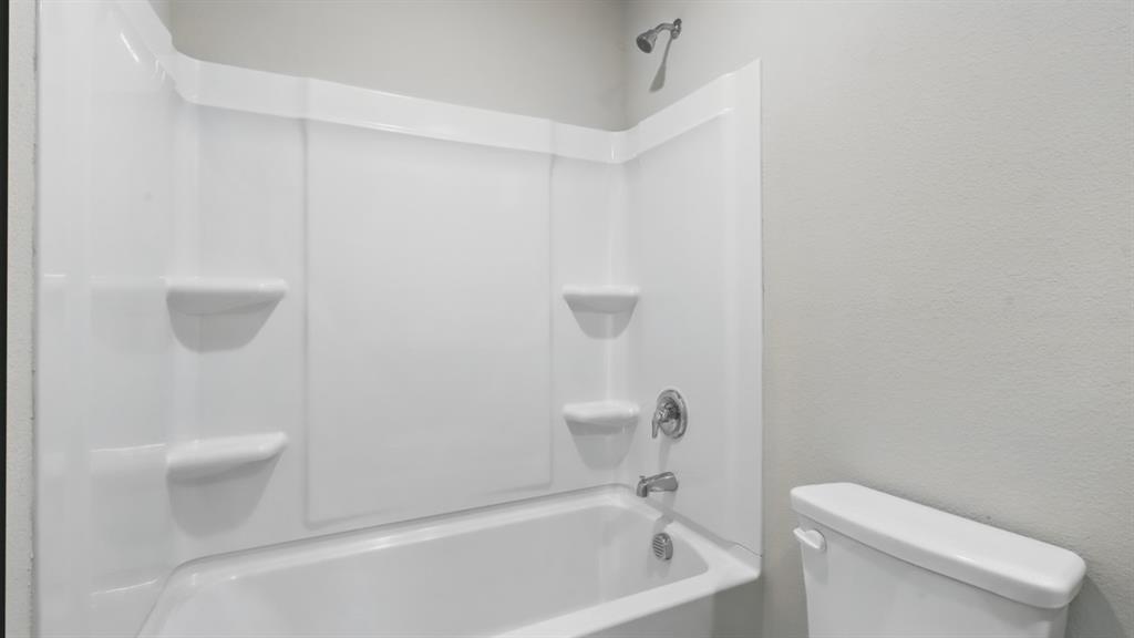 3152 Maple Orch Lane Fort Worth, TX 76140 - Photo 29 of 37 a white toilet sitting next to a bath tub
