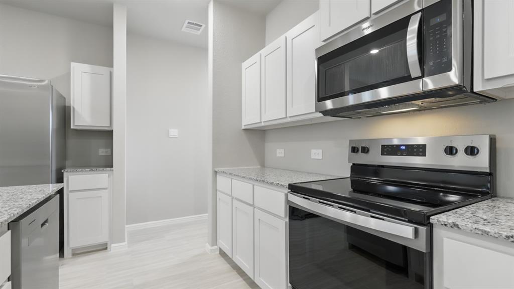3152 Maple Orch Lane Fort Worth, TX 76140 - Photo 4 of 37 a kitchen with stainless steel appliances granite countertop a stove and a microwave