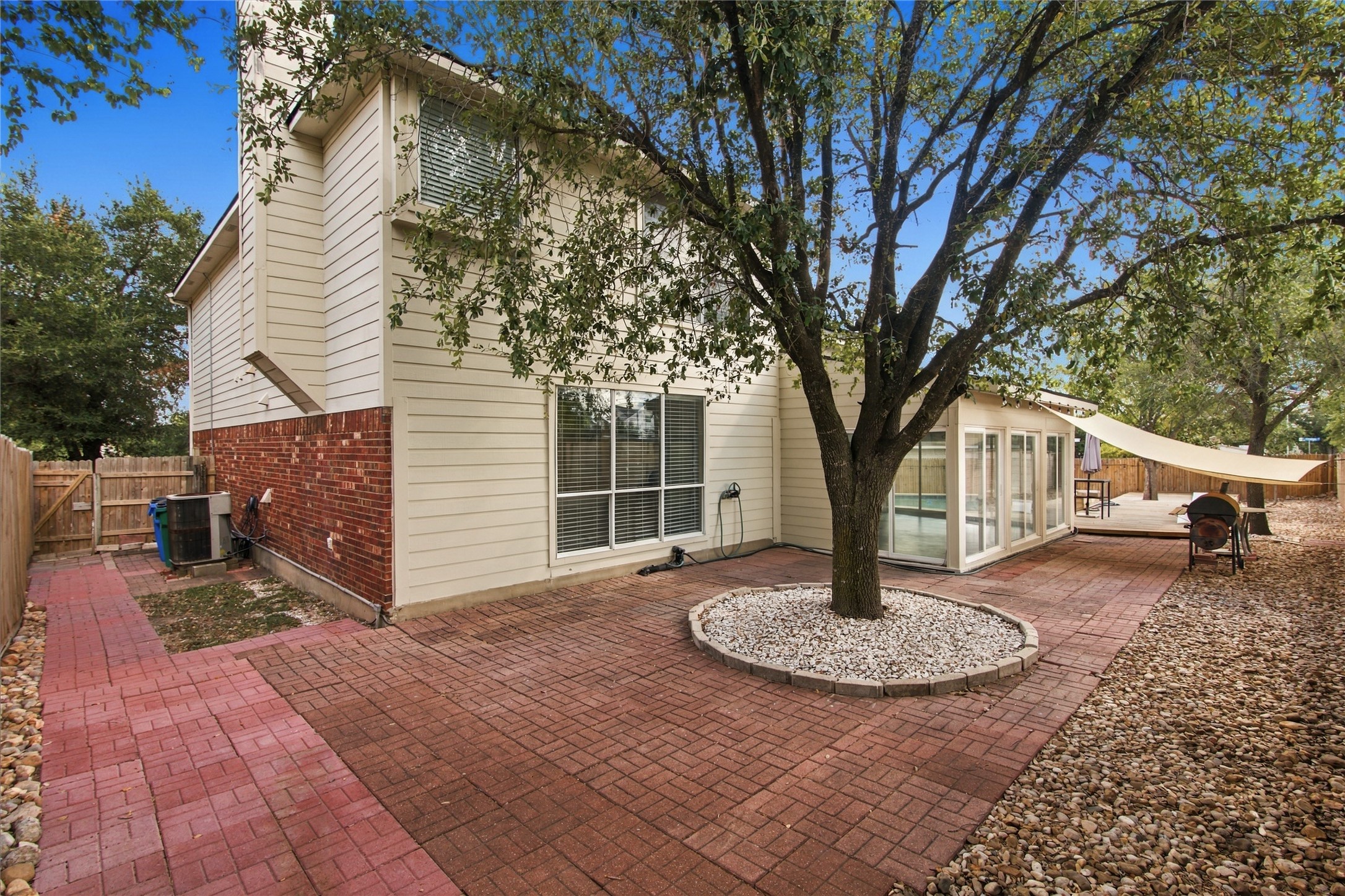 910 Point Run Drive Pflugerville, TX 78660 - Photo 32 of 39 A spacious brick paver patio extends across the backyard beneath mature shade trees.