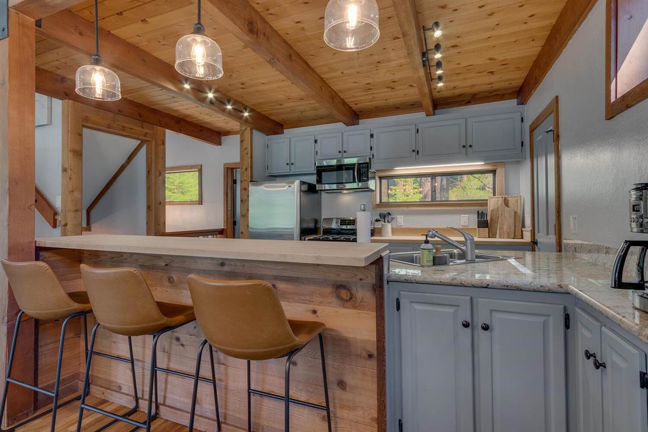 117 Basque Drive Truckee, CA 96161 - Photo 8 of 20 a kitchen with stainless steel appliances granite countertop a sink a stove and chairs