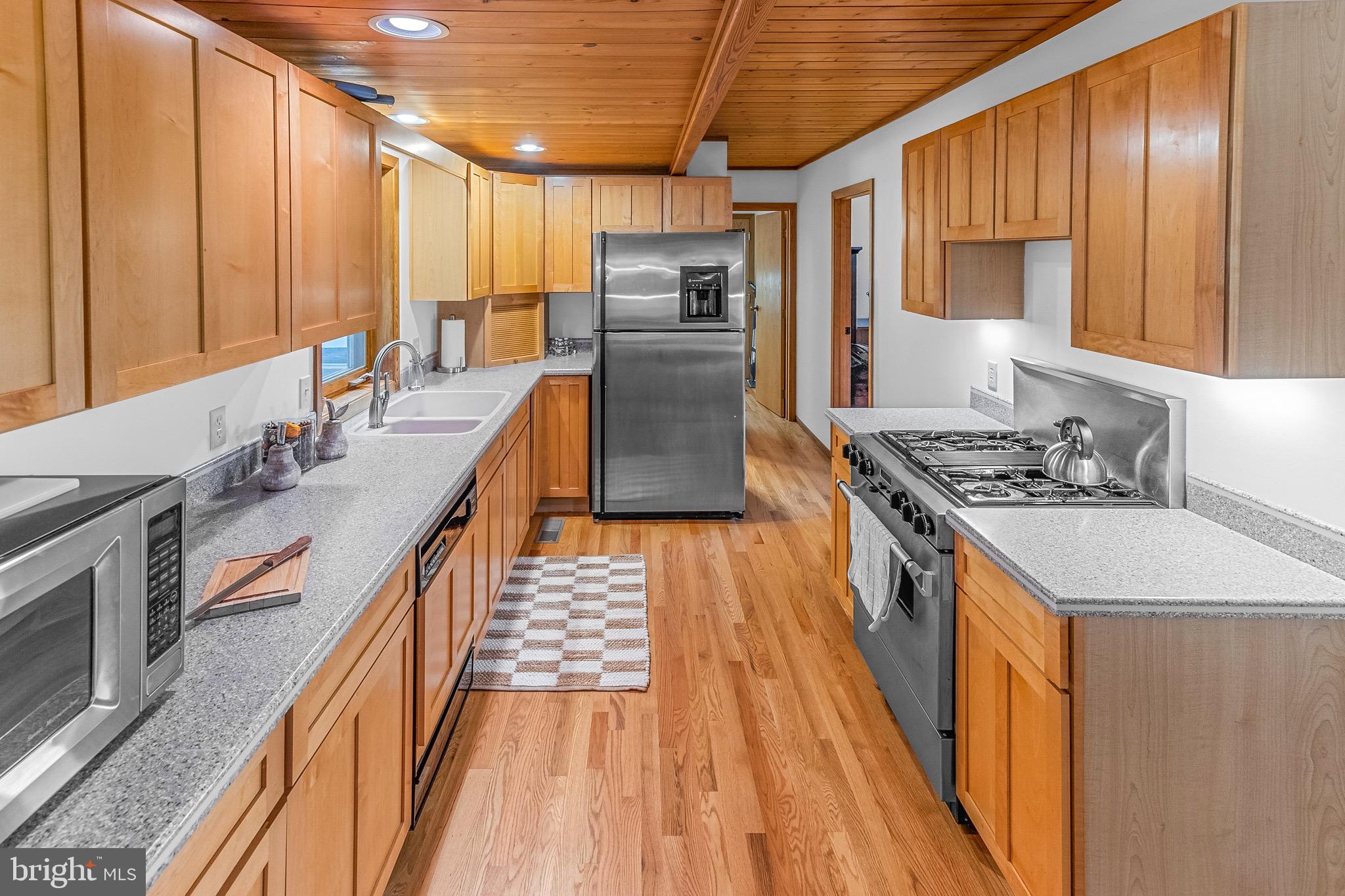 105 Rabbits Rest Lane Shepherdstown, WV 25443 - Photo 21 of 42 a kitchen with stainless steel appliances granite countertop a stove a sink dishwasher and a refrigerator with wooden cabinets
