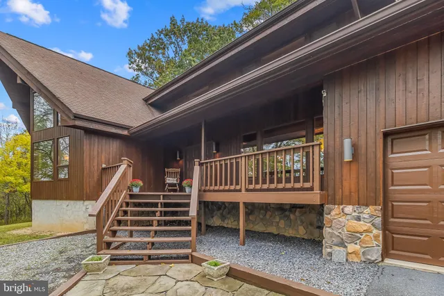 a balcony with stairs and a wooden bench