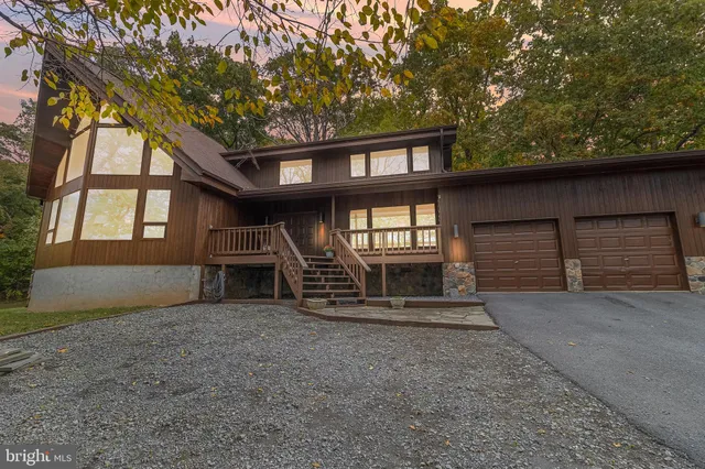 front view of a house with a large window and wooden fence