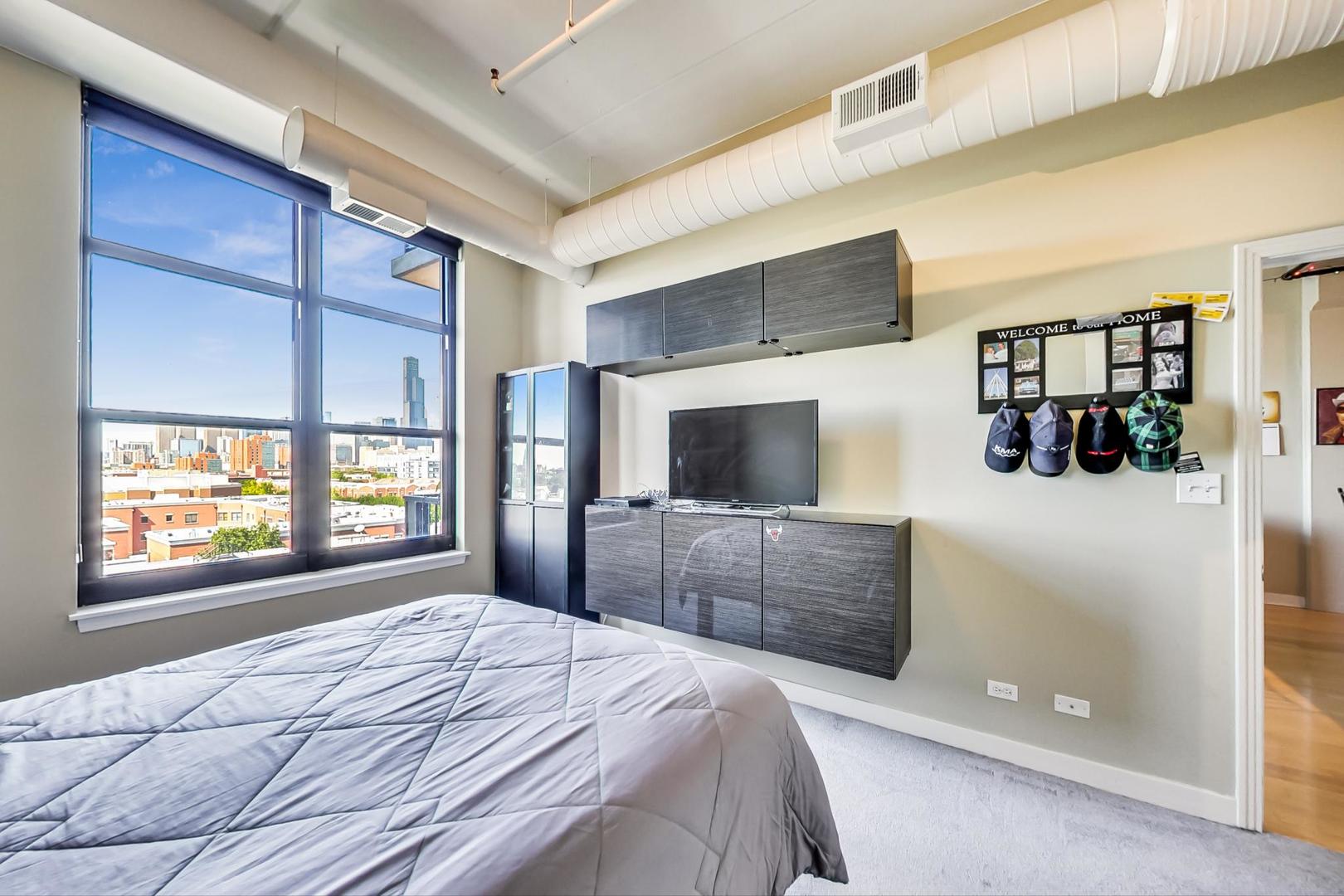 811 West 15th Place, Unit 606 Chicago, IL 60608 - Photo 11 of 22 a bedroom with a large bed and a television